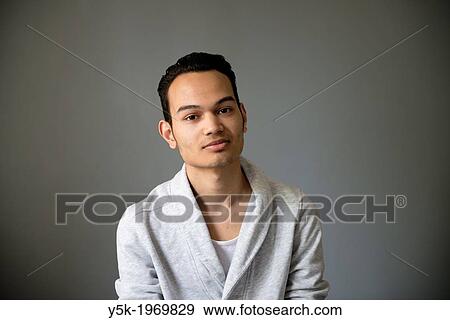 Tilburg, Netherlands. Studio-portrait of a Indonesian 3rt generation immigrant to the Netherlands against a grey background. View Large Photo Image Stock Photo - Tilburg, Netherlands. Studio-portrait of a Indonesian 3rt generation immigrant to the Netherlands against a grey background.. Fotosearch