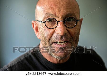 Tilburg, Netherlands. Studio-portrait of a bald, be glassed and middle-aged man, talking, speaking and telling a story. View Large Photo Image Stock Photo - Tilburg, Netherlands. Studio-portrait of a bald, be glassed and middle-aged man, talking, speaking and telling a story.. Fotosearch