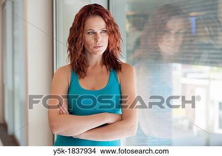 Picture - Tilburg, Netherlands. Young woman having a break during her workout in the gym.. Fotosearch