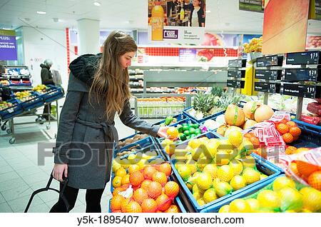 Tilburg, Netherlands. Young woman buying groceries in a supermarket. View Large Photo Image Stock Photo - Tilburg, Netherlands. Young woman buying groceries in a supermarket.. Fotosearch