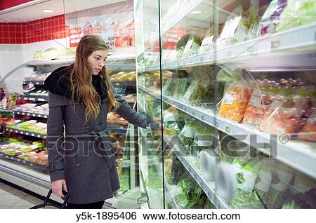 Tilburg, Netherlands. Young woman buying groceries in a supermarket. View Large Photo Image Stock Photograph - Tilburg, Netherlands. Young woman buying groceries in a supermarket.. Fotosearch