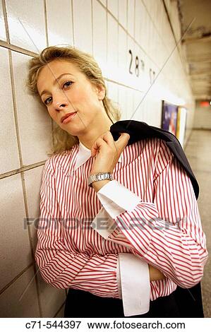Stock Photo - Tired caucassian businesswoman leaning on wall in subway station. Fotosearch