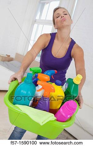 Tired young woman holding cleaning products View Large Photo Image Stock Image - Tired young woman holding cleaning products. Fotosearch