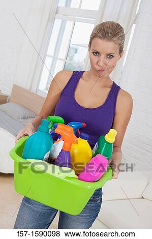Tired young woman holding cleaning products View Large Photo Image Stock Photo - Tired young woman holding cleaning products. Fotosearch