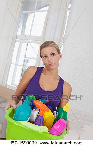 Tired young woman holding cleaning products View Large Photo Image Stock Photo - Tired young woman holding cleaning products. Fotosearch