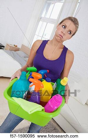 Tired young woman holding cleaning products View Large Photo Image Stock Photography - Tired young woman holding cleaning products. Fotosearch