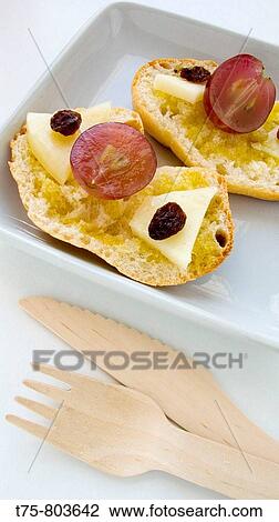 Stock Image - Toast with cheese, grapes and raisins. Fotosearch