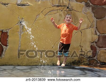 Toddler boy jumping in water fountain, Florida, USA. View Large Photo Image Stock Photo - Toddler boy jumping in water fountain, Florida, USA.. Fotosearch