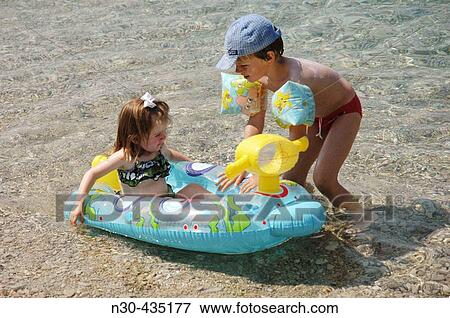 Toddler boy playing with toddler girl at beach. View Large Photo Image Stock Photo - Toddler boy playing with toddler girl at beach.. Fotosearch