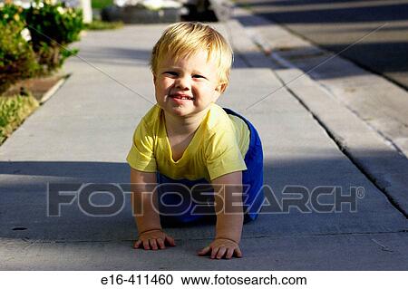 Stock Image - Toddler crawling on sidewalk. Fotosearch