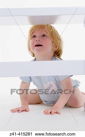 Toddler crawling under a bench View Large Photo Image Stock Image - Toddler crawling under a bench. Fotosearch