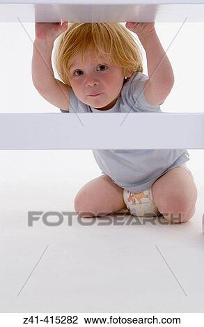 Toddler crawling under a bench View Large Photo Image Stock Image - Toddler crawling under a bench. Fotosearch