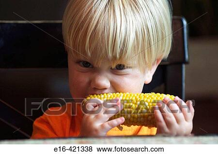 Toddler eating corn on the cob View Large Photo Image Stock Photo - Toddler eating corn on the cob. Fotosearch