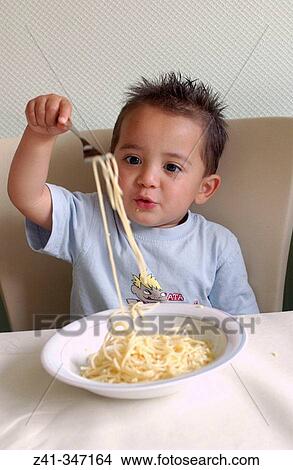 Toddler eating pasta View Large Photo Image Picture - Toddler eating pasta. Fotosearch