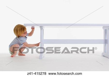 Toddler examining a bench View Large Photo Image Stock Photo - Toddler examining a bench. Fotosearch
