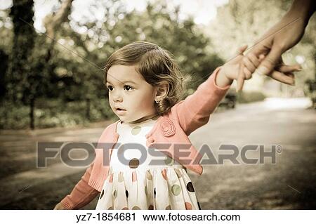Toddler girl holding on to mother's hand View Large Photo Image Stock Image - Toddler girl holding on to mother's hand. Fotosearch
