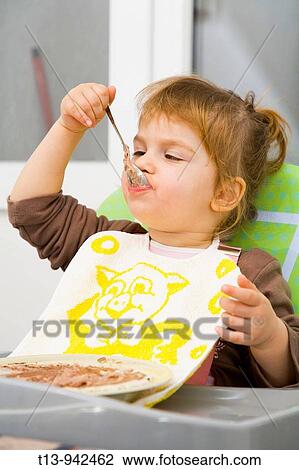 Toddler girl is eating with spoon View Large Photo Image Stock Image - Toddler girl is eating with spoon. Fotosearch