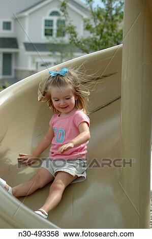 Stock Photo - Toddler Girl Sliding Downlide. Fotosearch