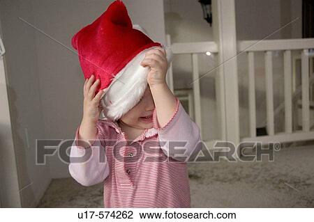 Toddler girl taking off Santa hat. View Large Photo Image Stock Image - Toddler girl taking off Santa hat.. Fotosearch