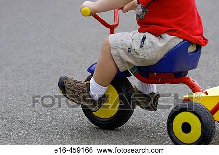Stock Photograph - Toddler on toy tricycle. Fotosearch