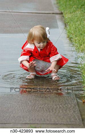 Toddler playing in puddle View Large Photo Image Stock Image - Toddler playing in puddle. Fotosearch