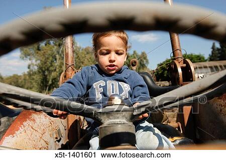 Toddler plays driver on an old tractor View Large Photo Image Stock Image - Toddler plays driver on an old tractor. Fotosearch