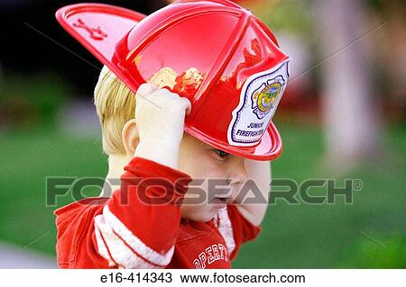 Toddler putting on fireman's hat View Large Photo Image Stock Image - Toddler putting on fireman's hat. Fotosearch