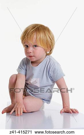 Toddler sitting on a bench View Large Photo Image Stock Image - Toddler sitting on a bench. Fotosearch