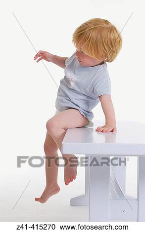 Toddler slides of a bench View Large Photo Image Stock Image - Toddler slides of a bench. Fotosearch
