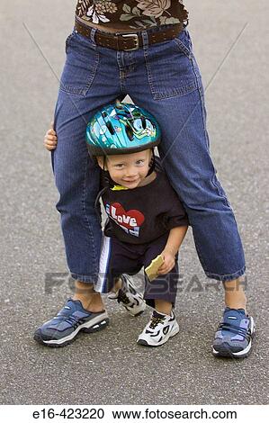 Toddler standing between mothers legs View Large Photo Image Stock Image - Toddler standing between mothers legs. Fotosearch