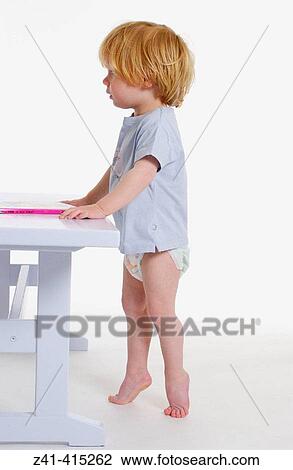 Toddler standing in front of a bench View Large Photo Image Stock Image - Toddler standing in front of a bench. Fotosearch