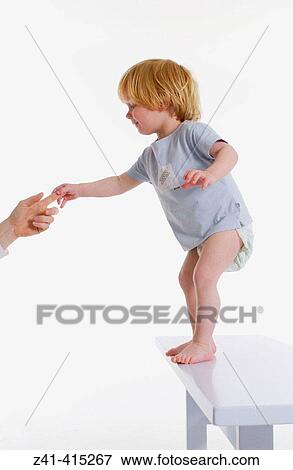 Toddler standing on a bench View Large Photo Image Stock Photo - Toddler standing on a bench. Fotosearch