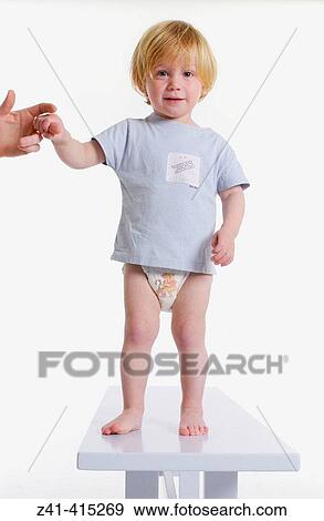 Stock Photo - Toddler standing on a bench. Fotosearch