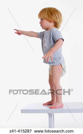 Stock Photo - Toddler standing on a bench. Fotosearch
