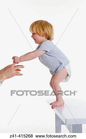 Stock Photo - Toddler standing on of a bench. Fotosearch