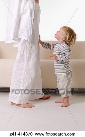 Toddler standing with mothers legs View Large Photo Image Stock Image - Toddler standing with mothers legs. Fotosearch