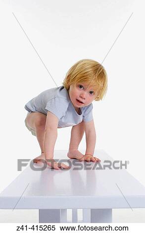 Toddler trying to stand on a bench View Large Photo Image Stock Photography - Toddler trying to stand on a bench. Fotosearch