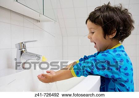 Stock Image - Toddler washing his hands. Fotosearch