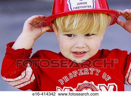 Stock Image - Toddler with fireman's hat. Fotosearch