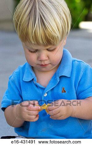 Stock Image - Toddler with orange slice. Fotosearch