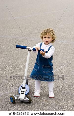 Toddler with scooter on street View Large Photo Image Stock Image - Toddler with scooter on street. Fotosearch
