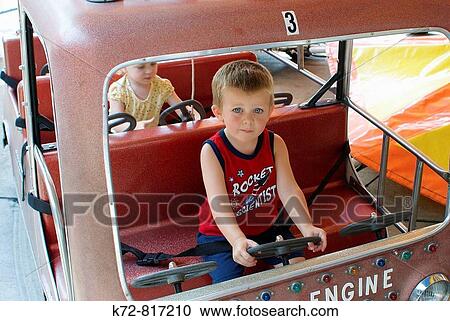 Toddlers riding in cars at an amusement park is a new and exciting adventure. View Large Photo Image Stock Image - Toddlers riding in cars at an amusement park is a new and exciting adventure.. Fotosearch