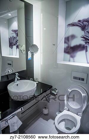 Stock Image - Toilet room in hotel. Interior design is in black white tones.. Fotosearch