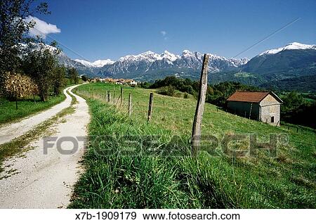 Stock Photo - Torch Pieve d? Alpago Italy Green pastures surrounded by mountains of the Dolomites in the Alpago region. Fotosearch