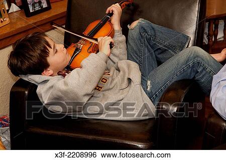 Total relaxation of young violinist practicing in his home. St Paul Minnesota MN USA. View Large Photo Image Stock Photograph - Total relaxation of young violinist practicing in his home. St Paul Minnesota MN USA.. Fotosearch