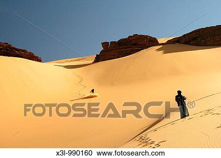 Touareg look at tourist slipping in dune Oued Tin Tarabine Tassili Ahaggar Sahara desert Algeria View Large Photo Image Stock Image - Touareg look at tourist slipping in dune Oued Tin Tarabine Tassili Ahaggar Sahara desert Algeria. Fotosearch