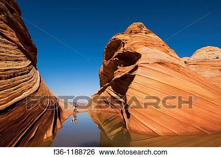 Tourist couple next to Seasonal desert pool of water below striated sandstone at The Wave, Coyote Buttes, Paria Canyon Vermilion Cliffs Wilderness, Arizona View Large Photo Image Stock Photograph - Tourist couple next to Seasonal desert pool of water below striated sandstone at The Wave, Coyote Buttes, Paria Canyon Vermilion Cliffs Wilderness, Arizona. Fotosearch