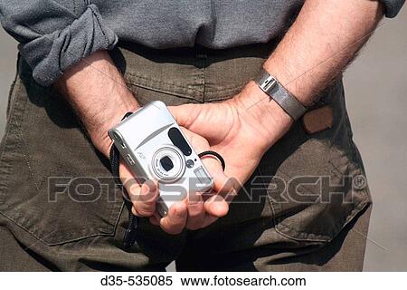 Tourist holding camera in his hands. View Large Photo Image Stock Photography - Tourist holding camera in his hands.. Fotosearch