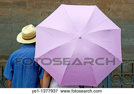 Tourist looking at a wall while sheltering under an umbrella, Temple of Heaven, Beijing, China View Large Photo Image Stock Photo - Tourist looking at a wall while sheltering under an umbrella, Temple of Heaven, Beijing, China. Fotosearch