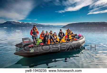 Stock Photography - Tourist on Zodiacs exploring and photographing Icebergs, Scoresbysund, Greenland.. Fotosearch